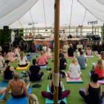 A yoga session being held in a tent at a festival