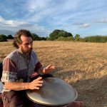 Man playing hand pan in field