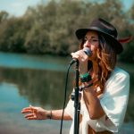 Lady singing in front of lake