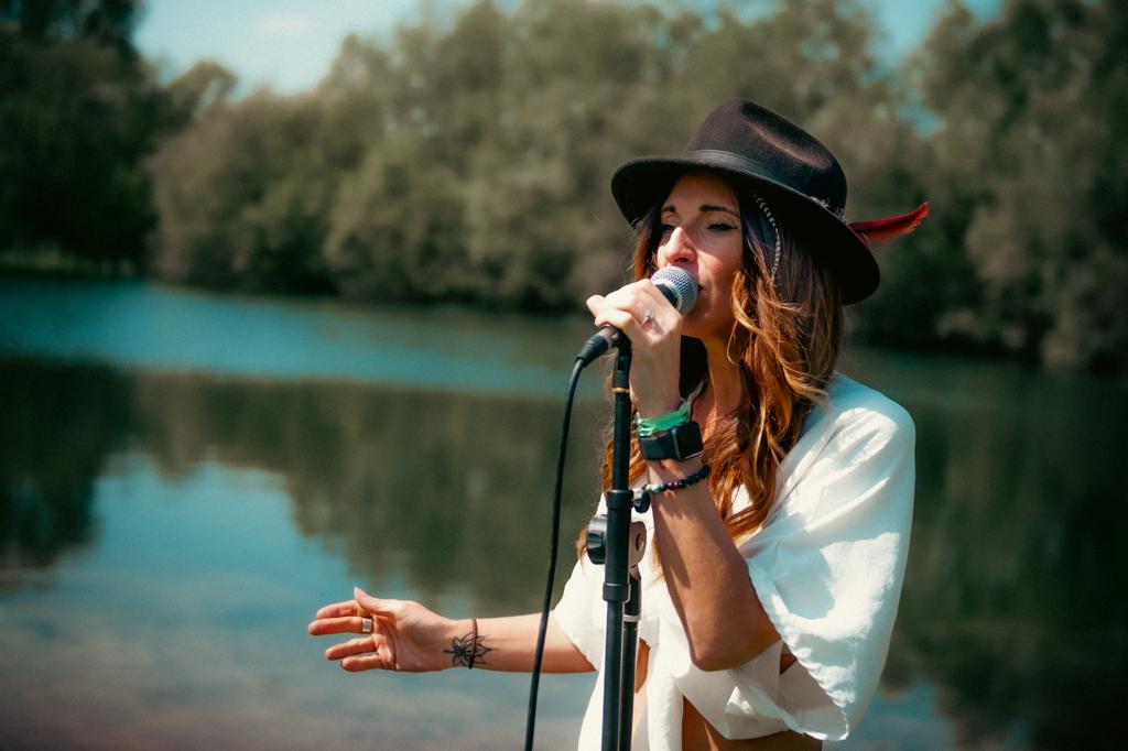 Lady singing in front of lake