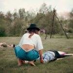 breathwork ceremony outside in nature woman grounding someone at the feet