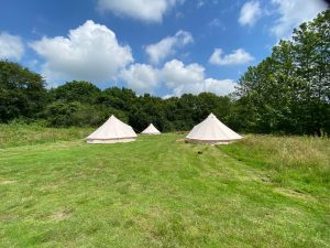 Three bell tents in field