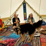 Two ladies playing harps in ceremony space at the Conscious Heart Warrior's healing village.