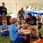 Adults and children enjoying a Fox drum circle at the Conscious Heart Warriors healing village for festival.