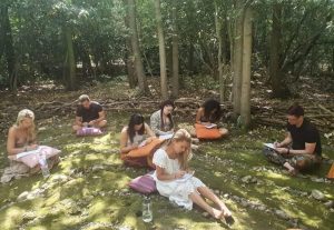 People sitting on floor journaling in nature at the Conscious Heart Warriors day retreat.
