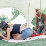 lady holding lady during a breathwork ceremony while man grounding at her feet